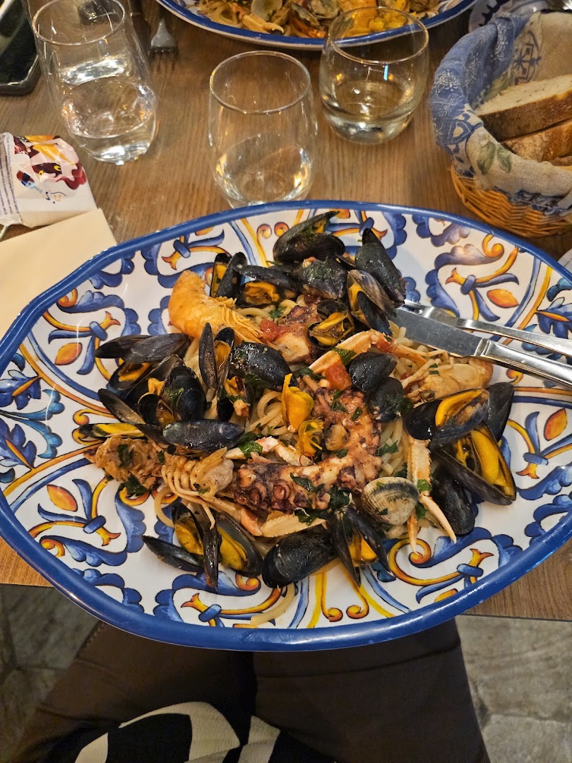 Des pâtes aux produits de la mer dans une assiette peinte