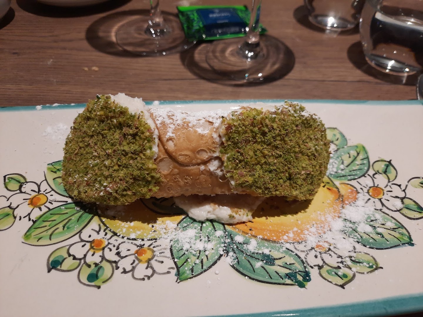 Un cannolo servi sur une assiette fleurie